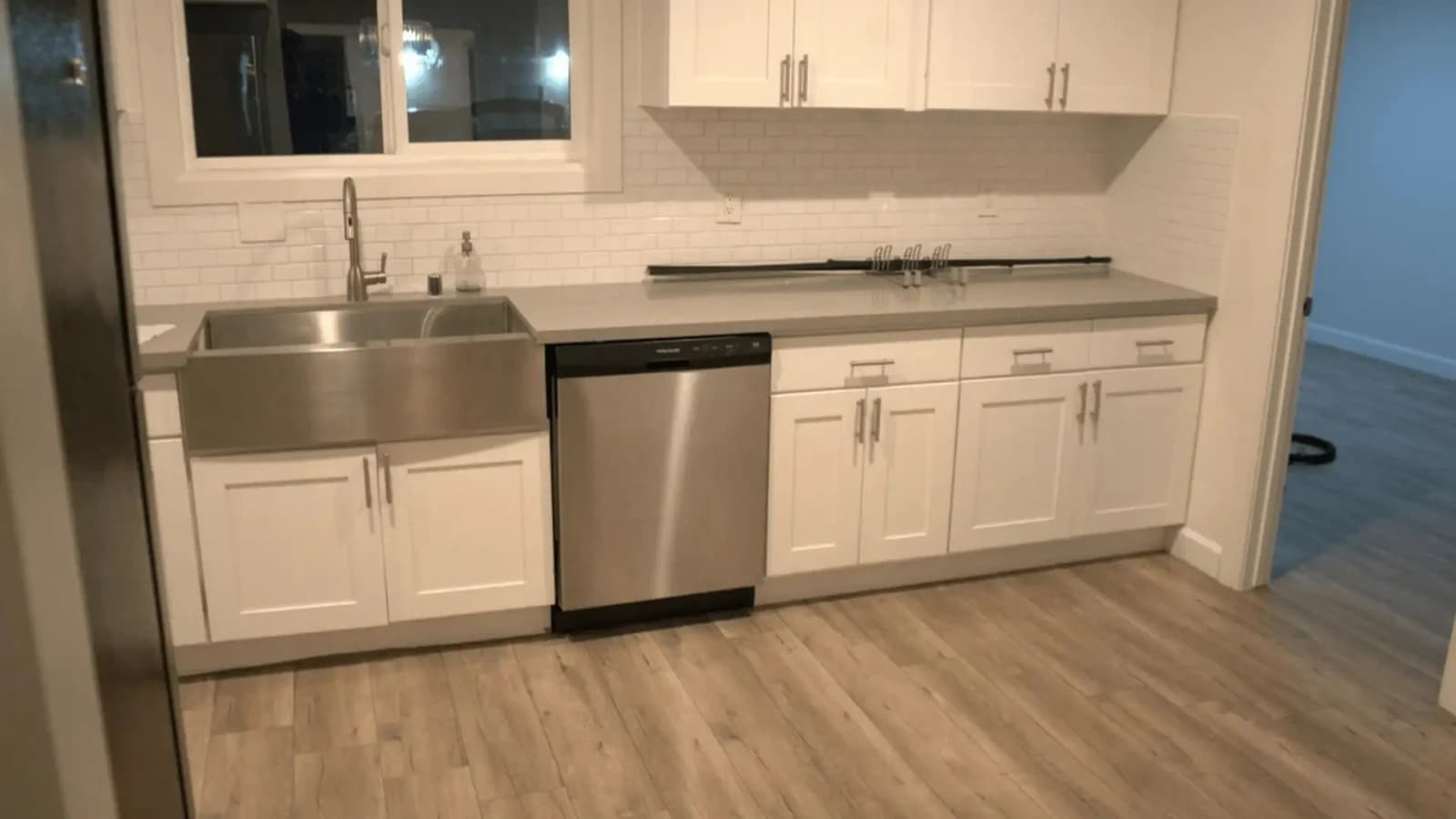 Kitchen with white cabinets, farmhouse sink and stainless dishwasher after a Flash Guys deep cleaning